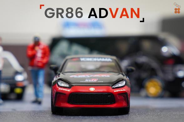 A front side of Toyota GR86 Advan livery by Pop Race in 1:64 scale with 1:64 figure on AREA 164