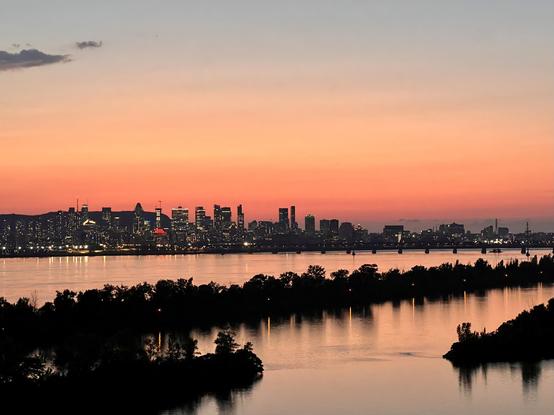 Cityscape of Montreal from Champlain Bridge with a sunset at the end