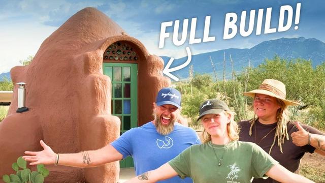 Thumbnail from YouTube video where a family poses in front of a SuperAdobe constructed building using alternative construction methods with eathbags