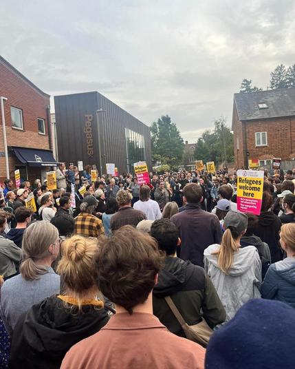 A large crowd of anti-racist demonstrators in a small suburban street