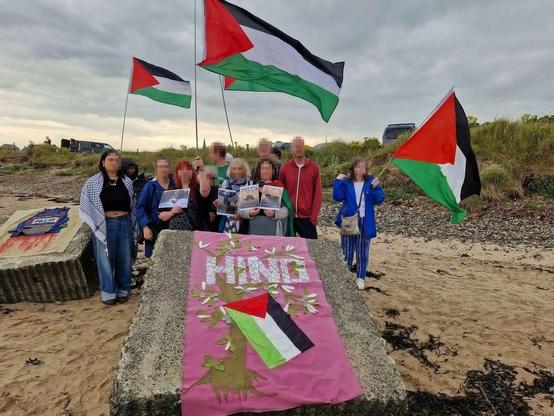 HIND banner at the beach 
With Palestine flags flying in the wind 