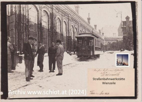 Das Sepia-Foto vom Dezember 1927 zeigt nach derzeitiger topografischer Einschätzung den schmalen west-ost-gerichteten Innenhof mit scheebedecktem Gleis, Blickrichtung Osten gegen die Anschützgasse, 6 Männer im Vordergrund, Straßenbahnwagon im hinteren Bildteil, Beschriftung "Straßenbahnwerkstätte Wienzeile, Archiv schlot.at