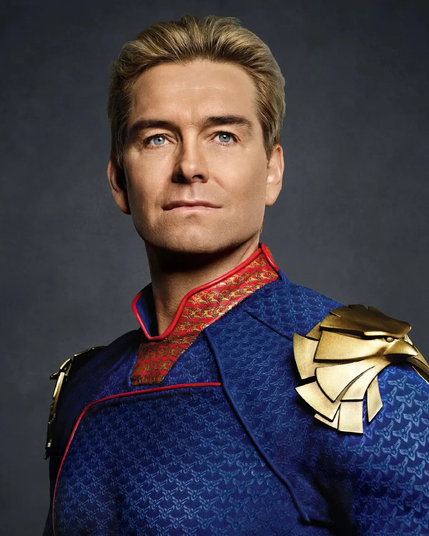 The image depicts the character Homelander from the TV series The Boys. He has a confident, almost regal expression, with short blonde hair and piercing blue eyes. He wears a dark blue superhero suit with intricate patterns, highlighted by red accents and a high collar featuring a red and gold design. On his right shoulder, there's a large gold shoulder pad shaped like an eagle's head, reinforcing his powerful and authoritative presence. Homelander is known for his commanding and often intimidating demeanor in the series.