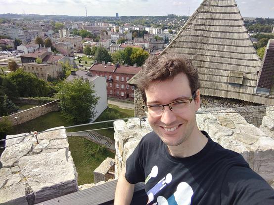 A man looking very happy to be stood at a castle.