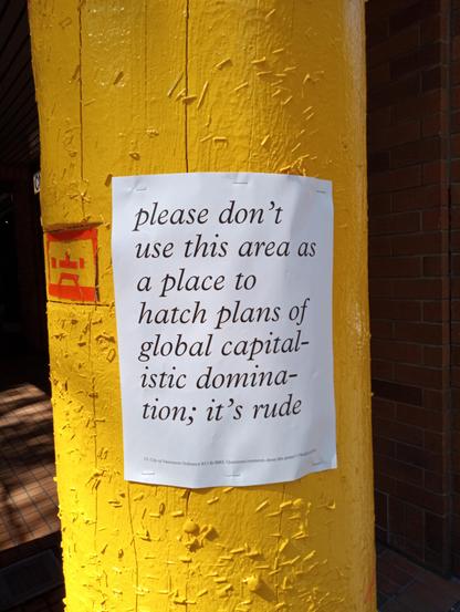 poster on telephone pole reading: 'please don't use this area as a place to hatch plans of global capitalistic domination; it's rude'