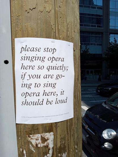 poster on telephone pole reading: 'please stop singing opera here so quietly; if you are going to sing opera here, it should be loud'