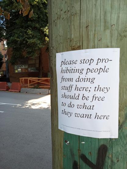 poster on telephone pole reading: 'please stop prohibiting people from doing stuff here; they should be free to do what they want here'