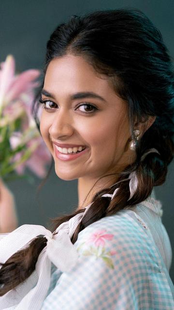 Keerthy Suresh brings a breath of fresh air to traditional fashion with her stunning blue gingham saree and sleeveless blouse combination. This look is the perfect blend of classic and contemporary, making it a top choice for fashion-forward individuals. The gingham print is trendy yet timeless, and Keerthy's styling adds a unique flair to the ensemble. Her confident pose and radiant charm make this look truly unforgettable.