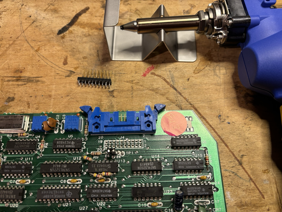 Circuit board with the broken header removed, showing clean solder pads and the Hakko FR-301 desoldering gun.
