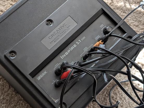 The back side of the subwoofer of the desktop speakers. The back identifies them as Creative Labs Inspire 5300 5.1 speakers. They are EAX certified.