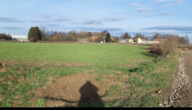 Aus der Ferne sieht man erst wie idyllisch und klein das Dorf lützerath ist. Rechts sieht man bereits eine ausgebaggerte Befestigung, eine Trasse,  wo später das schwere Räumfahrzeug entlang fahren wird. 