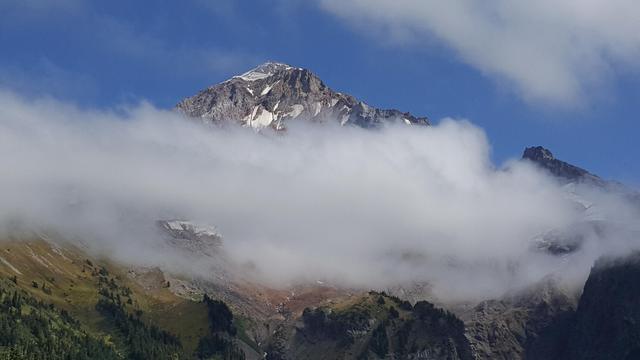 A snow-capped mountain behind clouds