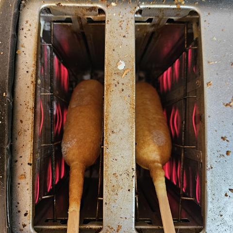 2 corndogs in a standard toaster. Using begal setting. The elements glow red and there is still a bit of frost on the surface of the battered dog. You know they are done when the sizzling is at climax and the smell of the lightly browned outer layer smells irresistible.