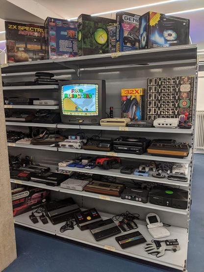 a shelf with a lot of video consoles