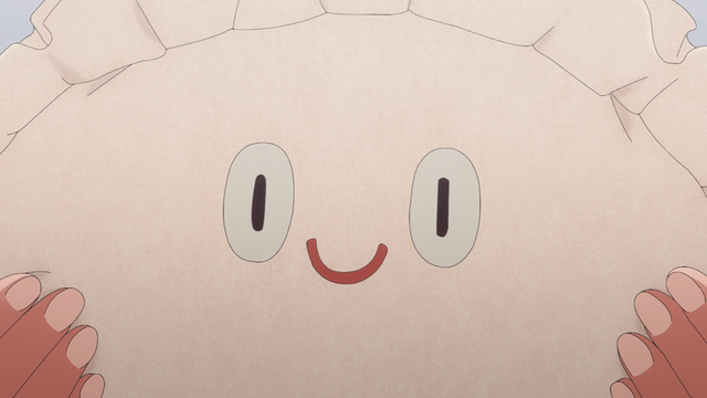 A close up of the face on the side of a plush gyoza.