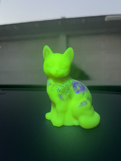 The same figurine now glowing bright green under blacklight