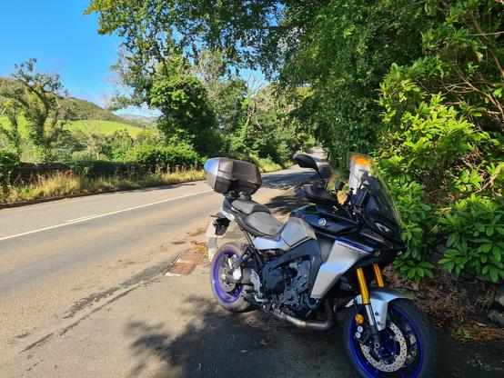 A yamaha Tracer 9 parked next to the TT course