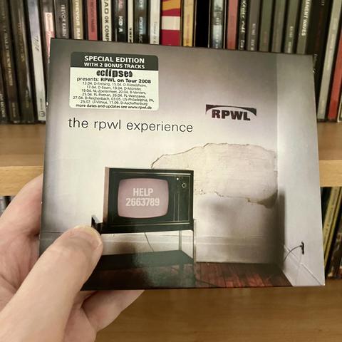 Picture of the The RPWL Experience CD while I'm holding it in front of the CD shelf it's normally stored.