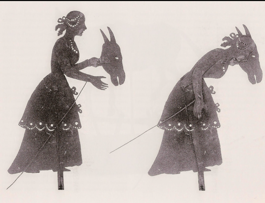 Shadow puppet of a woman putting on a donkey mask