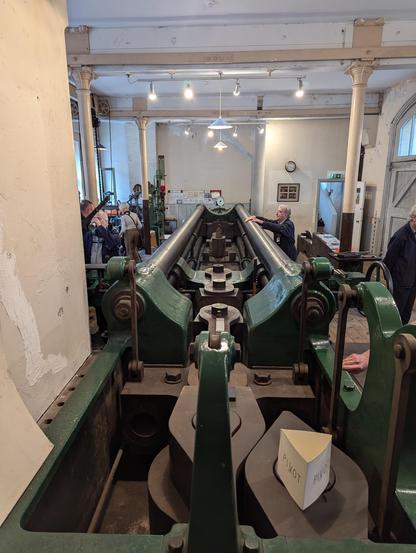 Looking down the length of the Kirkaldy machine. Lots of green painted steel and massive screws. 