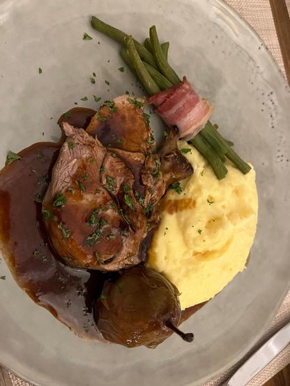 Un deuxième plat principal de la Bénichon. Gigot d'agneau, poire caramellisée, sauce brune, purée et haricots verts au lard.