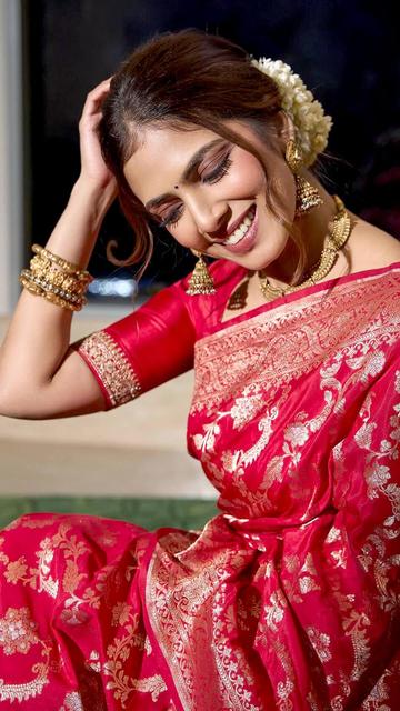 In a red Banarasi saree that’s as vibrant as her personality, Malavika Mohanan has captivated the internet. This traditional saree, adorned with exquisite gold detailing, is the highlight of her latest look that’s gone viral. Malavika’s sophisticated style, paired with her effortless charm, makes this ensemble a standout. The saree’s rich texture and her minimalistic styling create a perfect harmony, making this look both timeless and trendy. Don’t miss out on this viral fashion moment!