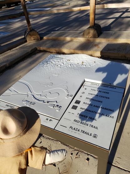 Ranger Sarah a Park Ranger Doll stands in the bottom left looking at a map of Devils Tower
