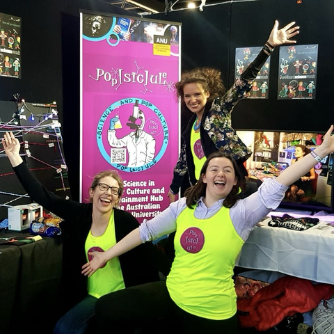 Three smiling ladies with jazz arms at the popsicule booth