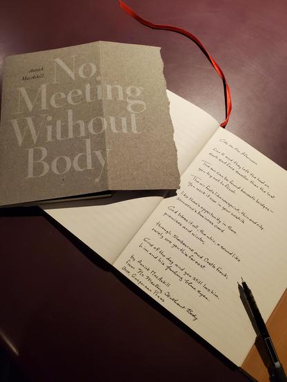 Handwritten transcription of the poem "Ode on the Afternoon" from the poetry collection No Meeting Without Body by Annick MacAskill - the collection's cover is opened out next to the notebook page, on which rests an uncapped black pen