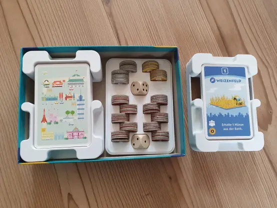 3D-printed inlay for the board game Machi Koro, showing organized cards and game components neatly arranged in the custom insert.