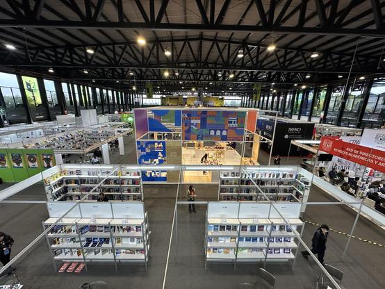 Panoramic view of the convention hall where FILUNI is taking place. Many stands are visible, with Udelar's stand at the center.