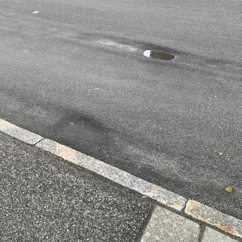 Spor i asfalten ved en bussholdeplass. Etterhvert blir synker den ned ganske mye.