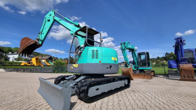 Gebrauchte Minibagger auf bau und Einsatz. Neuer Blog Artikel rund zum Thema Baumaschinen und Minibaggre. Das Foto zeigt einen gebrauchten 8 to Kompaktbaggre von IHI der auf einem Lagerplatz zum Verkauf steht.