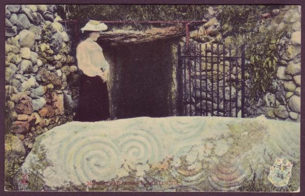 A vintage colour postcard showing a woman standing between the triple spiral sculptured megalith and the entrance to Newgrange Passage Grave in Meath, Ireland. This card is erroneously titled "Mellifont Abbey, Co. Louth". 