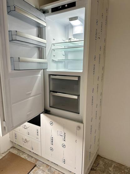 Kühlschrank mit damunterliegendem Tiefkühler. Der Kühlschrank ist offen und eingeschaltet.