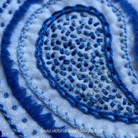 Up close of embroidery stitches done in blues. 
