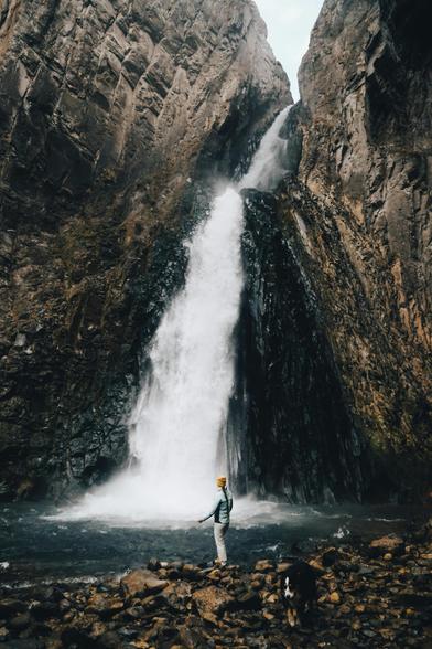 Cascada que se abre paso con fuerza a través de una gran roca. El riachuelo inferior tiene poca profundidad, pero tiene muchas rocas redondeadas.