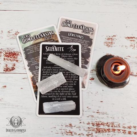 A set of 3 cards are arranged on a whitewashed wood surface. Each card in the "Sacred Home Cleansing Expansion Pack for the Eclectic Witch Card Deck- March 2022" features information on some of the ways you can cleanse your home and sacred space. This is an exclusive product from Inked Goddess Creations.
