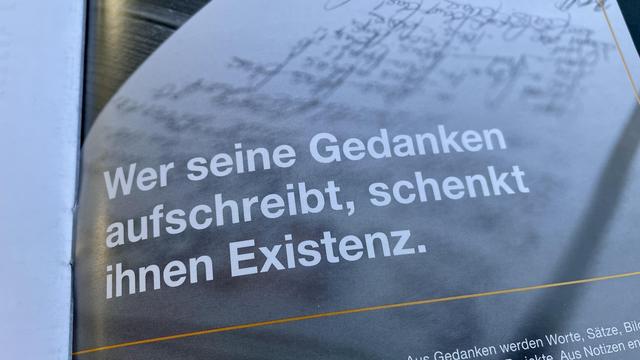 Auf dem Bild steht der Satz: „Wer seine Gedanken aufschreibt, schenkt ihnen Existenz.“