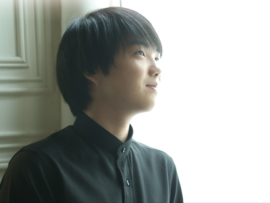 Portrait of Mao Fujita, a young japanese man with a very bright lit background.
He looks away with a gentle expression.