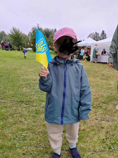 Kuva pojastani, naama peitetty, Ukrainan lipun kanssa