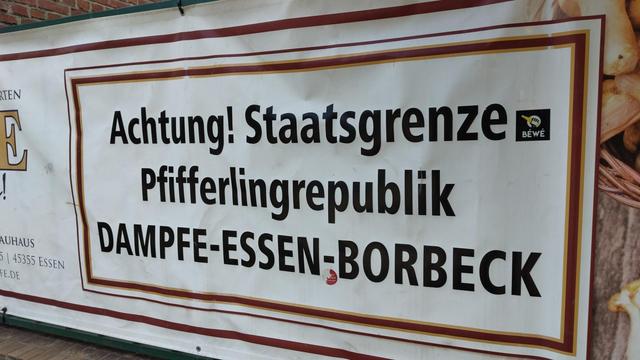 Werbebanner mit Aufschrift: Achtung! Staatsgrenze Pfifferlingrepublik Damofe Essen-Borbeck