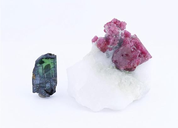 On the left, a clear crystal in a deep green like an underwater scene. On the right, berry-pink crystals top an opaque white rock. Image from the Smithsonian Institute.