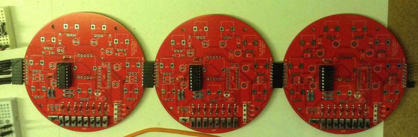 Three of my round, red, Baby 8 sequencer PCBs, each only partly populated, cascaded together.