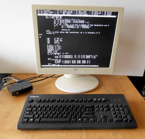 Agon Light 2 computer with a modern 19-inch flat screen monitor and a PC keyboard attached. The screen shows the NOE text editor with a T3X program loaded.