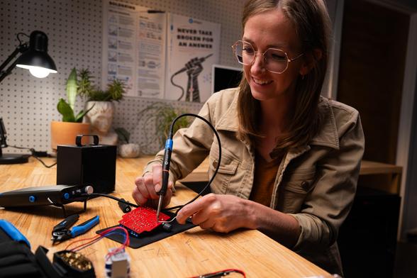 a maker uses the iFixit FixHub portable soldering station to repair a PCB