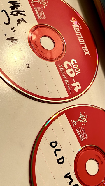 2 red 2002 burned mp3 cd-r’s sitting on a white desk. 
