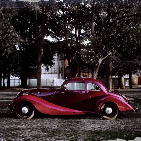 a vintage motor car, a Bristol by make. claret red in colour and with beautiful curving lines all over. not a single straight edge. 