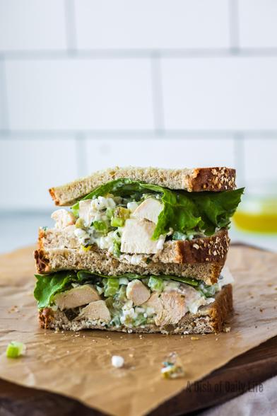 A cottage cheese chicken salad sandwich cut in half and stacked on top of each other.  