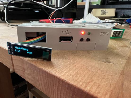 A gotek floppy emulator with an OLED display sticking out of the display reading flashfloppy 3.42